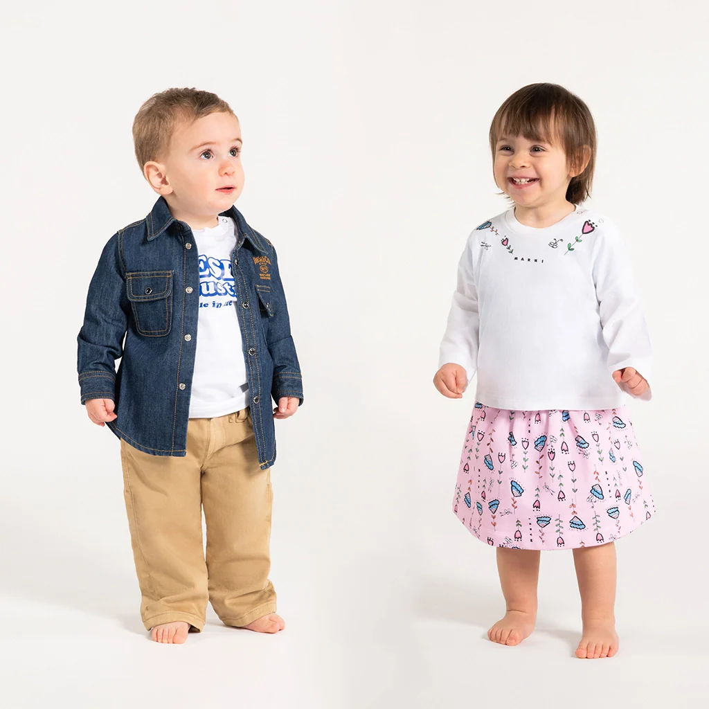 A baby boy and a baby girl wearing both cool outfits