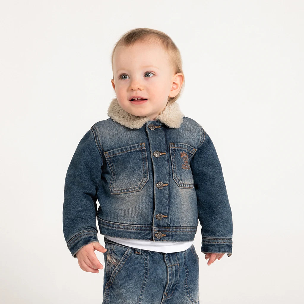 Baby wearing a total look denim on a neutral background.