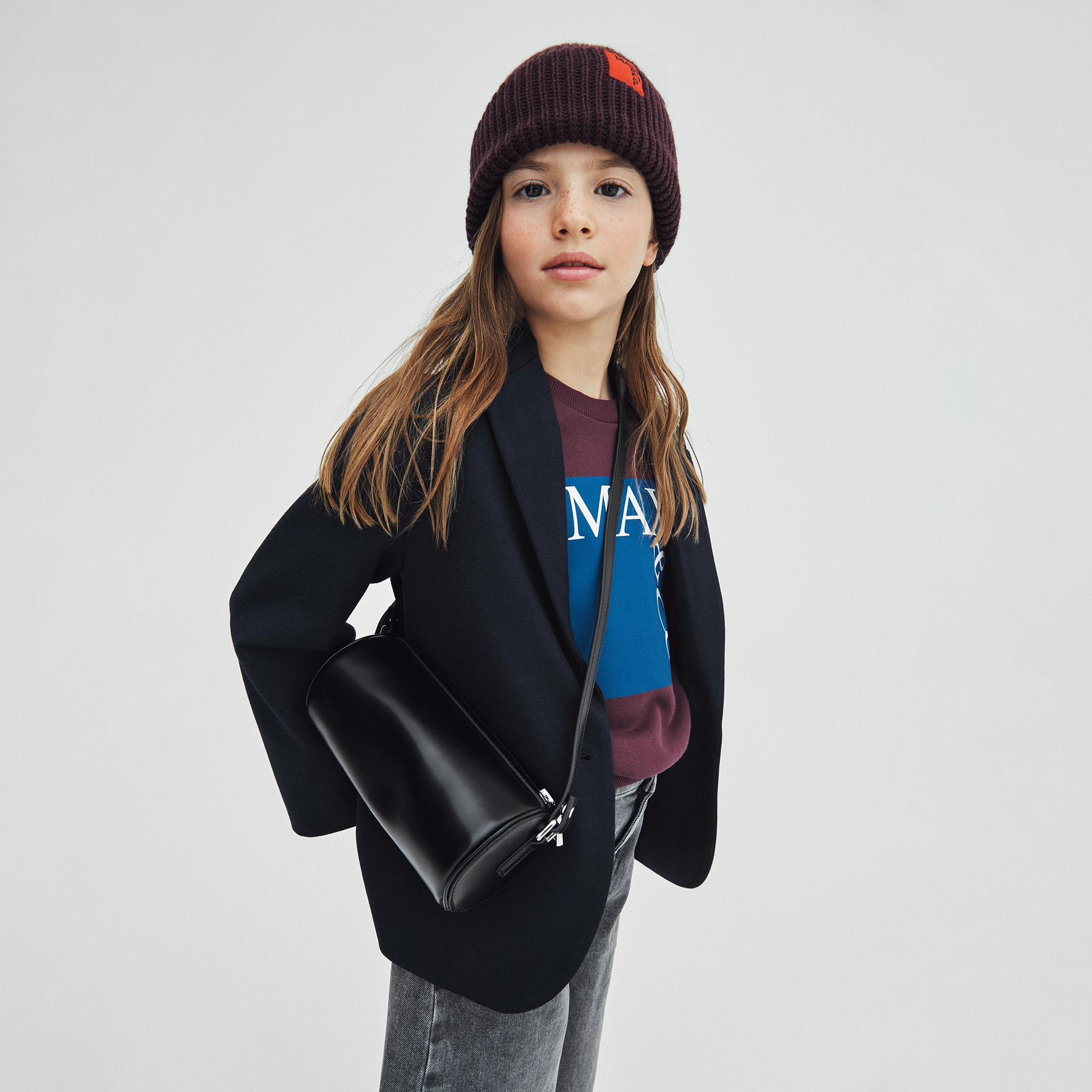 A girl wearing a stylish look with a black bag